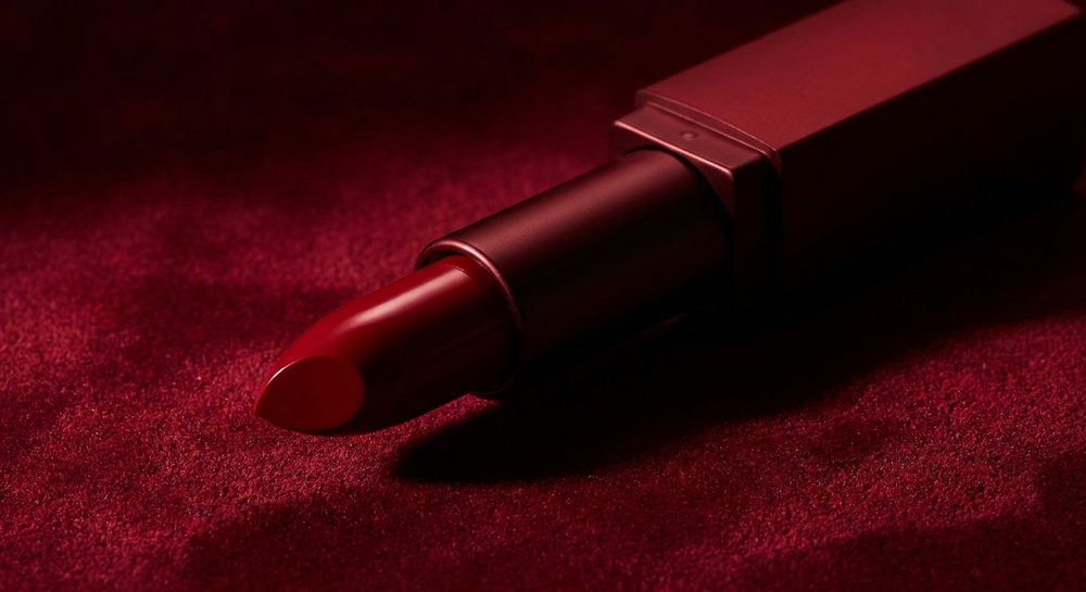 Red lipstick on deep red backdrop, dramatic light